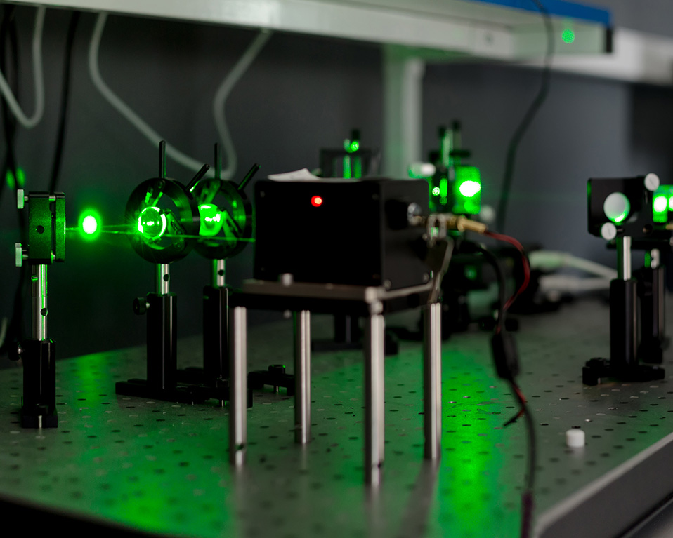 Rayos láser verdes entre los elementos ópticos de un laboratorio